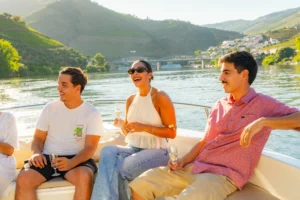 Grupo de amigos a bordo de um barco no Douro a apreciar a paisagem e o sol