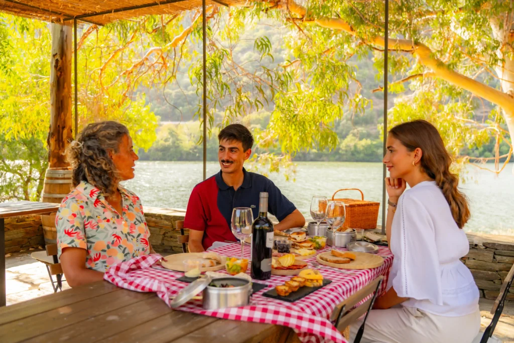 Casal a desfrutar de um almoço típico duriense à beira-rio durante o Tour Douro Experience da Deltatur